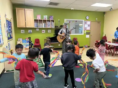 Child learning to play instruments in Kids Adventure Learning Center's music enrichment program developing rhythm, melody, and musical expression